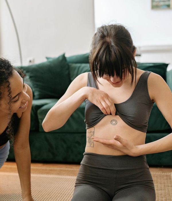 A woman performing a yoga stretch, showing flexibility and focus in a bright, airy space.